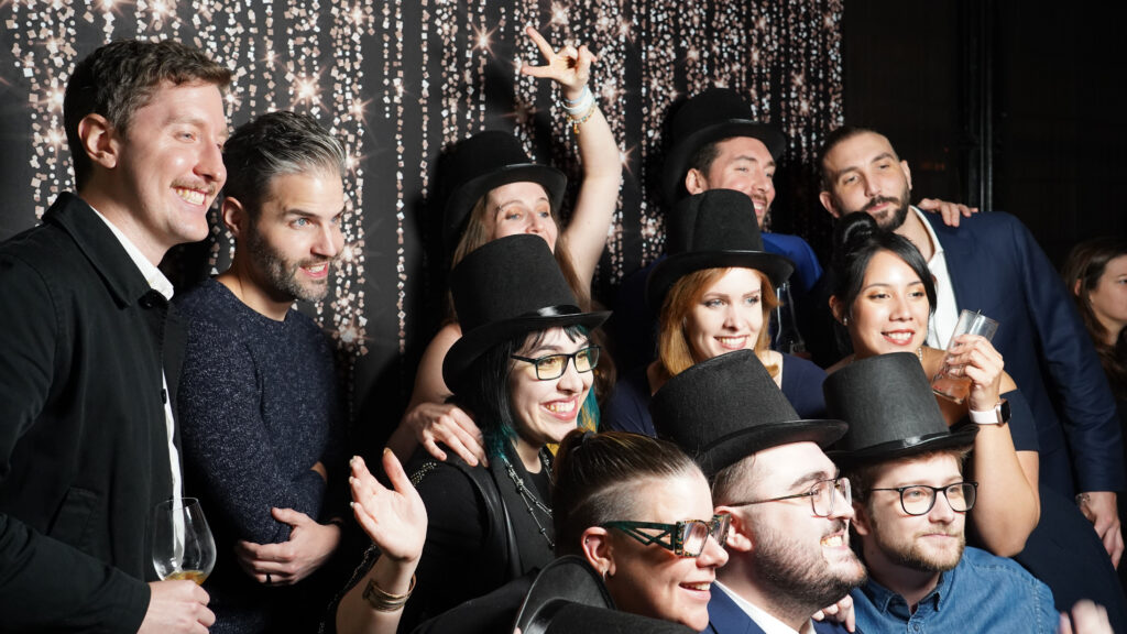 Employés de Reflector en chapeaux haut-de-forme posent pour une photo lors de la fête de fin d’année. 